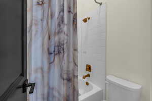 Bathroom featuring shower / tub combo and toilet