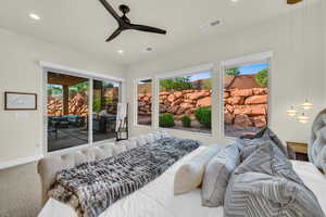 Carpeted bedroom with access to outside and ceiling fan