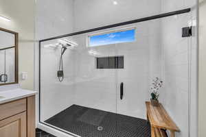 Bathroom with vanity and a shower with door