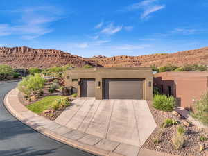 Pueblo-style house featuring a garage and a mountain view