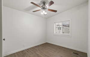 Empty room with dark hardwood / wood-style floors and ceiling fan