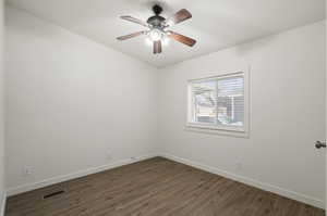 Spare room with ceiling fan and dark hardwood / wood-style floors