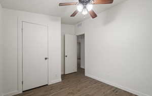 Unfurnished bedroom with ceiling fan and hardwood / wood-style floors