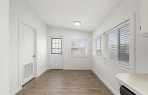 Interior space featuring lofted ceiling and light hardwood / wood-style flooring