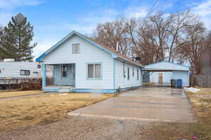 Bungalow-style house with a front yard, a carport, and a porch