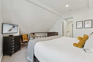 Carpeted bedroom with crown molding and vaulted ceiling