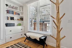 Sitting room with hardwood / wood-style flooring and ornamental molding