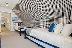 Bedroom featuring ornamental molding, light colored carpet, and vaulted ceiling