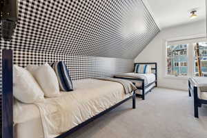 Bedroom featuring light carpet and lofted ceiling