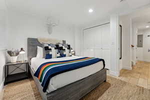 Bedroom featuring crown molding, electric panel, light tile patterned flooring, and a closet