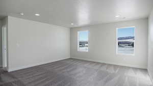 Carpeted empty room featuring a textured ceiling