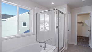 Bathroom with independent shower and bath and tile patterned flooring