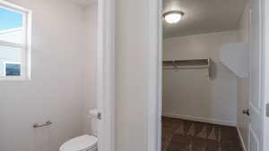 Bathroom featuring toilet and a textured ceiling