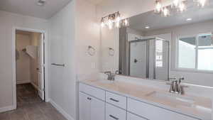 Bathroom with vanity, an enclosed shower, and tile patterned floors