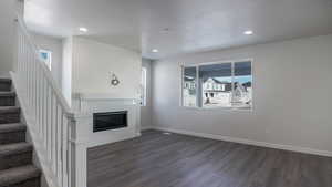 Unfurnished living room featuring dark wood-type flooring and a textured ceiling