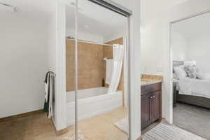 Bathroom featuring tile patterned flooring, vanity, and shower / bath combo with shower curtain