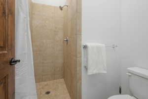 Bathroom with a shower with curtain and toilet