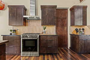 Kitchen featuring backsplash, dark brown cabinets, stainless steel gas range oven, and wall chimney exhaust hood