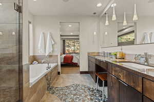 Bathroom featuring vanity and tiled bath