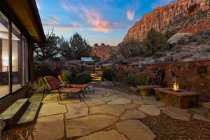 Patio terrace at dusk featuring an outdoor fire pit and a mountain view