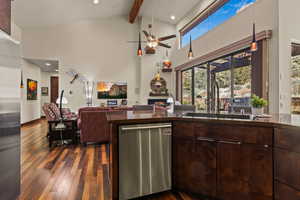 Kitchen with high vaulted ceiling, sink, dark hardwood / wood-style flooring, stainless steel appliances, and beam ceiling