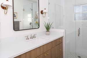 Bathroom with vanity and a shower with door