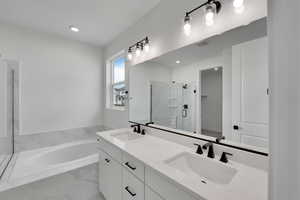 Bathroom with a garden tub, a sink, a stall shower, and visible vents