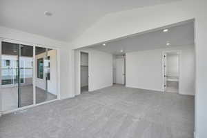 Spare room featuring carpet, lofted ceiling, recessed lighting, and visible vents