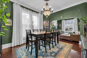 Dining space featuring dark hardwood / wood-style flooring, a wealth of natural light, and ornamental molding