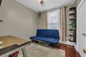 Bedroom area featuring dark hardwood / wood-style floors and ceiling fan