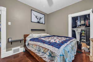 Bedroom with hardwood / wood-style floors, ceiling fan, and a closet