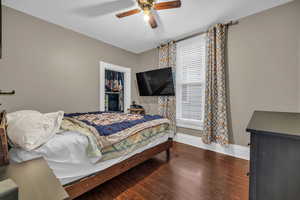 Bedroom with hardwood / wood-style flooring, ceiling fan, a closet, and multiple windows