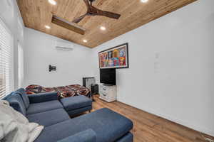 Studio/Office with vaulted ceiling, wooden ceiling, a wall unit AC, ceiling fan, and light hardwood / wood-style floors