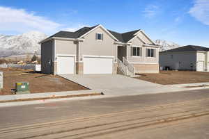 View of front of property with a garage and a mountain view