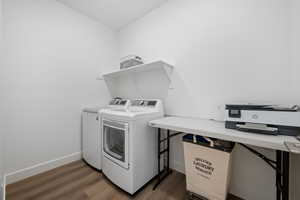 Laundry area with dark hardwood / wood-style floors and washer and dryer