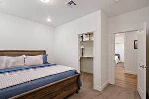 Carpeted bedroom featuring a spacious closet and a closet