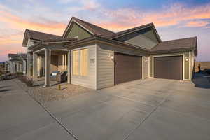 Property exterior at dusk with a garage and covered porch