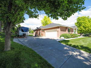 View of front of house with a garage, a front yard, and cooling unit