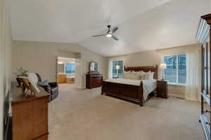 Carpeted bedroom featuring lofted ceiling, connected bathroom