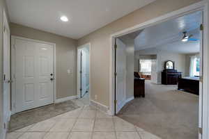 Carpeted foyer with a wealth of natural light and ceiling fan