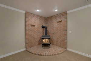 Interior details featuring carpet floors, ornamental molding, and a wood stove