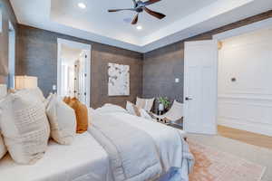 Bedroom featuring ceiling fan and a tray ceiling