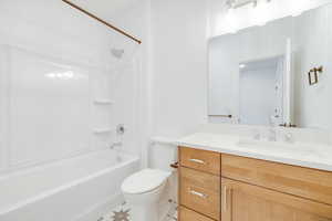 Full bathroom with vanity, tub / shower combination, and toilet