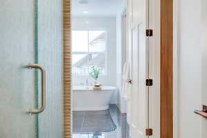 Bathroom featuring a washtub and tile walls