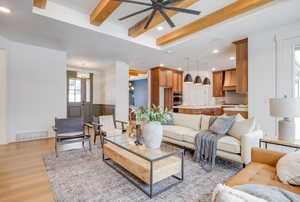 Living room featuring beamed ceiling, ceiling fan, and light hardwood / wood-style floors