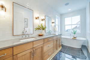 Bathroom with vanity, a bathing tub, and tile walls