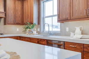 Kitchen featuring sink, decorative backsplash, and dishwasher