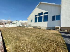 Back of home with lots of windows and a grassy area