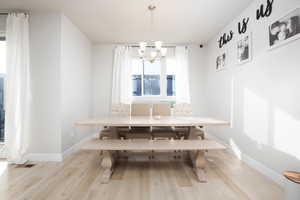 Dining space with breakfast area, light hardwood / wood-style flooring, and a chandelier