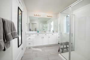 Bathroom featuring walk in shower, tile patterned floors, and vanity